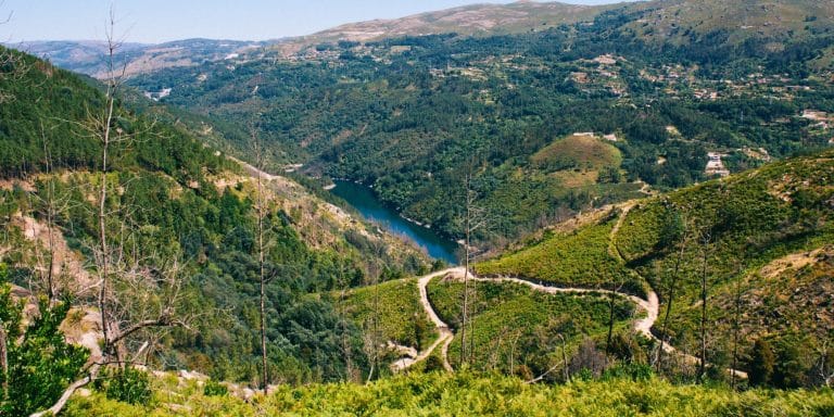 Vista panorámica del Parque Natural do Alvão con montañas verdes, senderos y un río que recorre el valle.