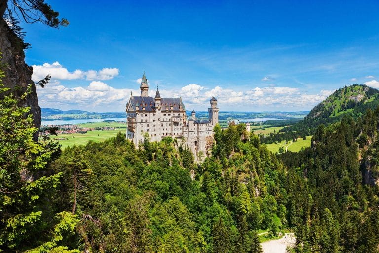 Castillo de Neuschwanstein rodeado de bosques y paisajes verdes en Baviera, Alemania.