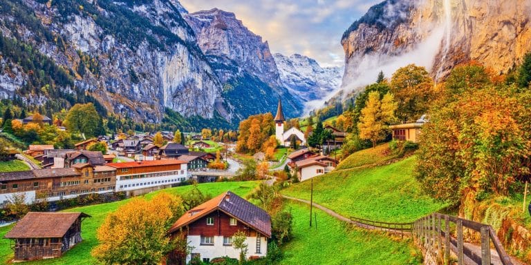 Vista del valle de Lauterbrunnen en otoño con cascada y casas alpinas en Suiza