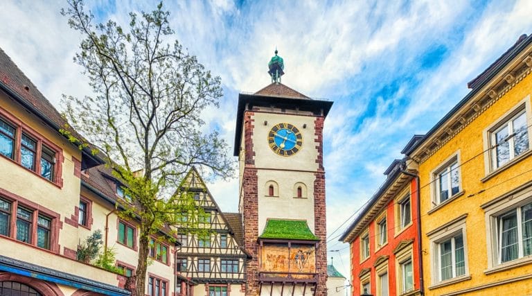 Puerta medieval Schwabentor en Friburgo Alemania con torre del reloj y casas de colores alrededor