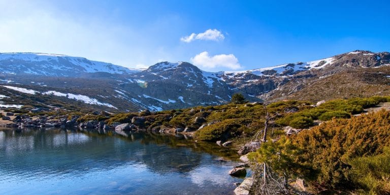 Lago de montaña en el valle del Madriu-Perafita-Claror en Andorra con picos nevados al fondo