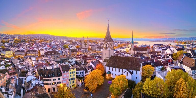 Vista panorámica de Zúrich al atardecer con la iglesia de San Pedro y el lago de fondo en Suiza