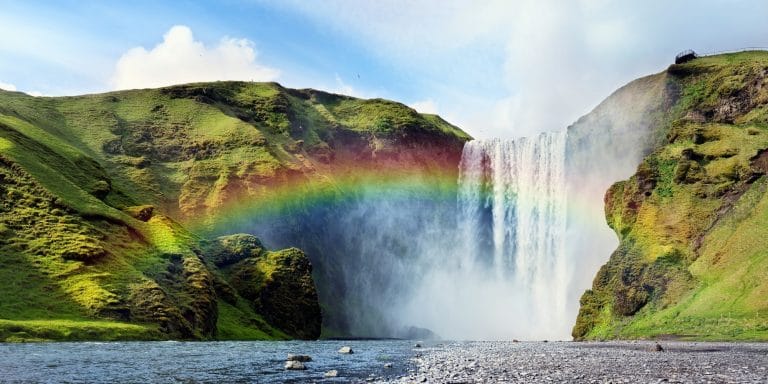 Cascada Skógafoss con arcoíris sobre el agua en Islandia