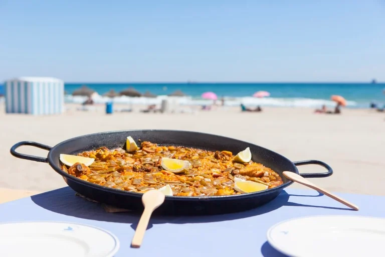 Paella tradicional en la playa de Valencia, disfrutando de la gastronomía mediterránea junto al mar