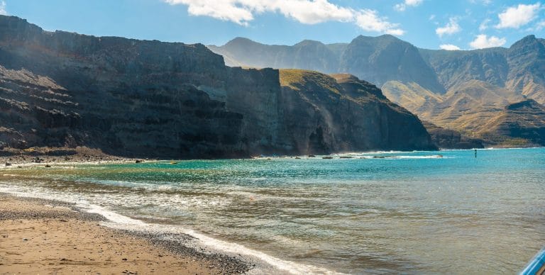 Playa de Puerto de Las Nieves en Agaete, Gran Canaria, con aguas cristalinas y paisaje volcánico.