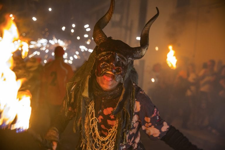 Persona con máscara de cuernos en medio de una ardiente celebración en Zamora