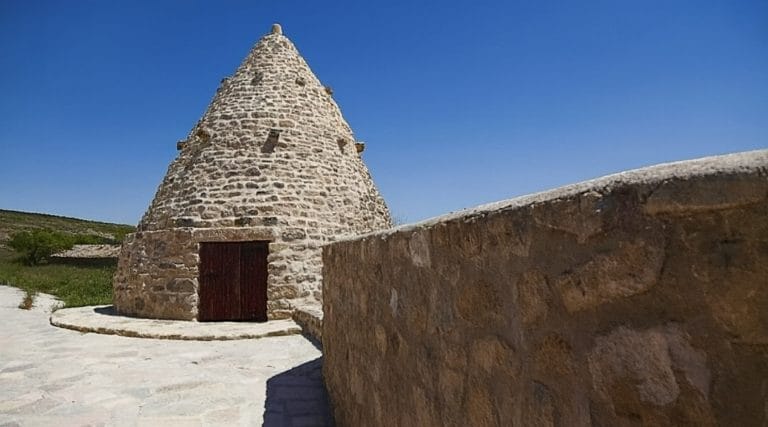 Nevera del Calvario en Fuendetodos Zaragoza construcción de piedra en forma cónica bajo un cielo azul