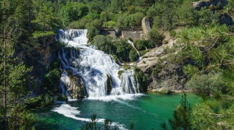 Cascada del Salto de Poveda en el río Tajo rodeada de bosque y montañas