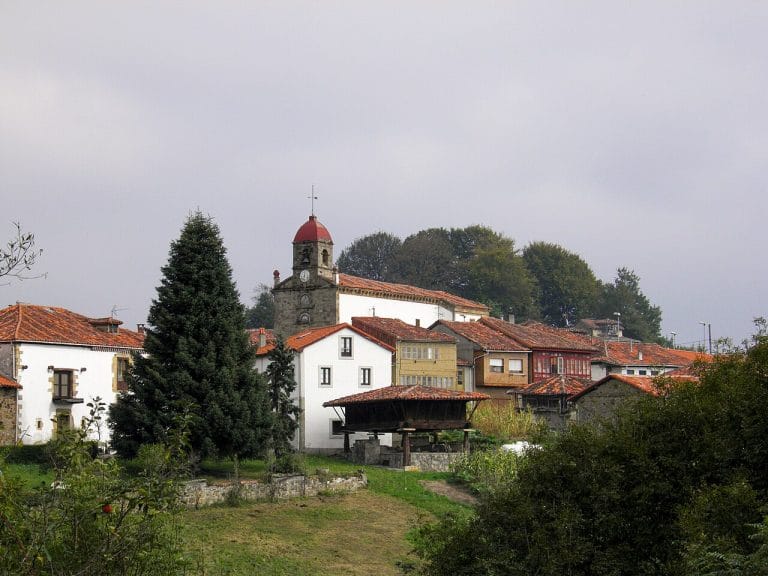 Vista del pueblo de Torazo en Cabranes, Asturias, con casas tradicionales, iglesia de torre roja y tejados de teja