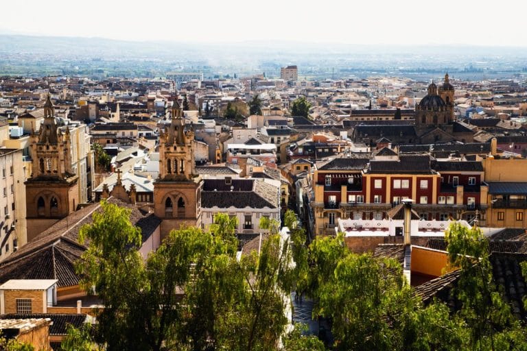 Vista panorámica del barrio del albaicín en granada con sus tejados y torres bajo la luz suave de la mañana.