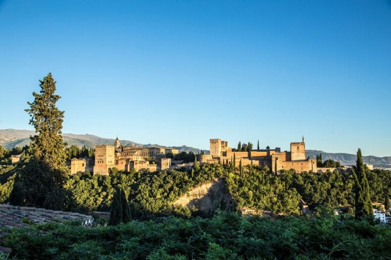 Atardecer sobre la alhambra con las últimas luces del sol iluminando sus muros.