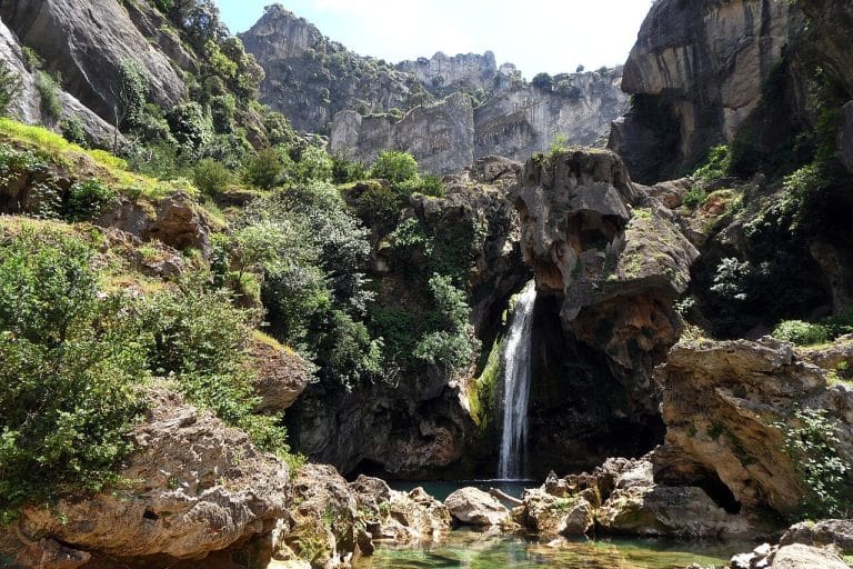 Cascada de la Calavera con salto de agua entre formaciones rocosas y vegetación exuberante en el parque natural de Cazorla