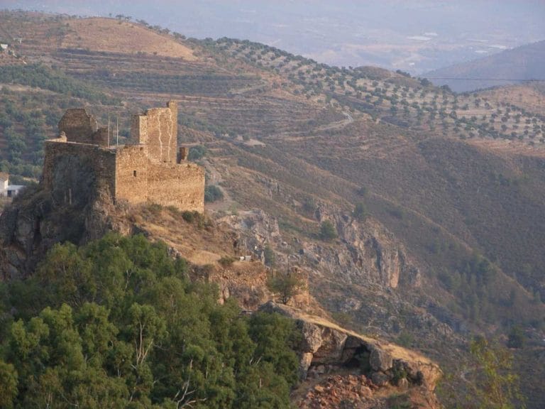 Pueblo de Lanjarón situado en la falda de la sierra nevada con bancales de olivos y casas blancas dispersas.