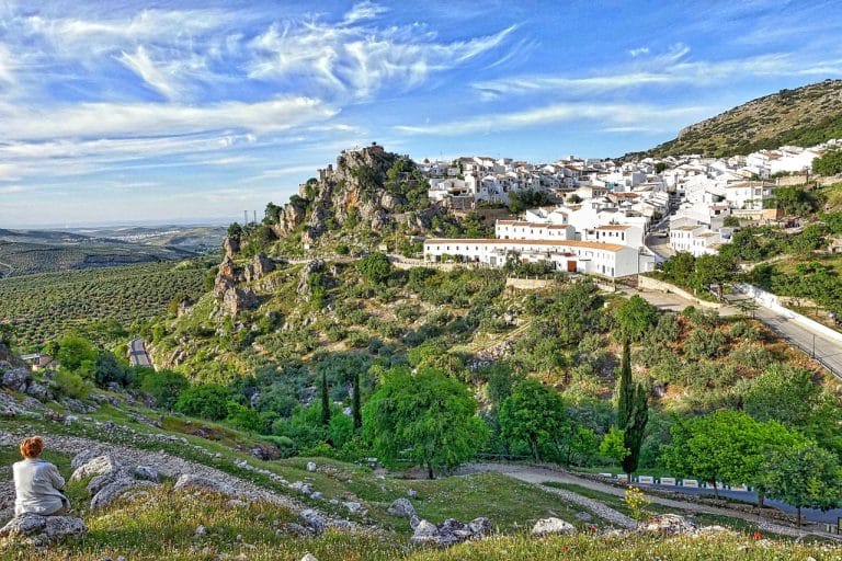 Vista panorámica del pueblo de Zuheros en Córdoba, con casas blancas enclavadas entre montañas y olivares.
