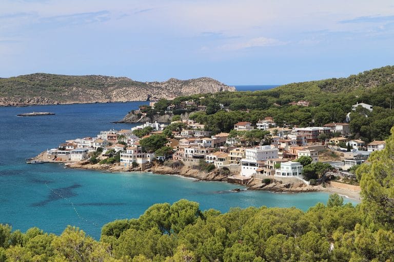 Vista panorámica de la costa de Sant Elm en Mallorca con aguas turquesas junto a formaciones rocosas y vegetación costera.