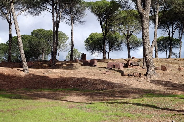 Restos de tumbas excavadas en roca entre pinares en la necrópolis de La Dehesa, en la provincia de Huelva