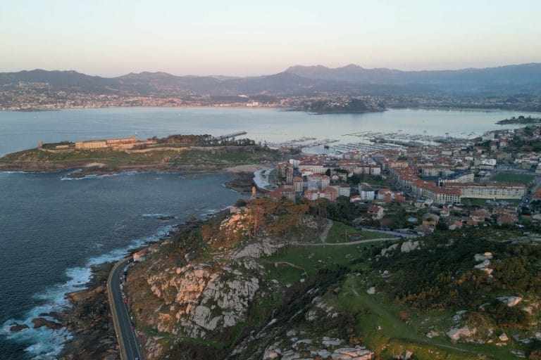 Vista aérea de Baiona al atardecer, con el Parador de Monterreal, el puerto deportivo y la costa recortada de las Rías Baixas.
