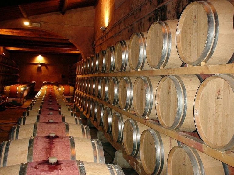 arriles de roble apilados en la bodega de crianza de Bodega Jumilla, donde envejecen los vinos