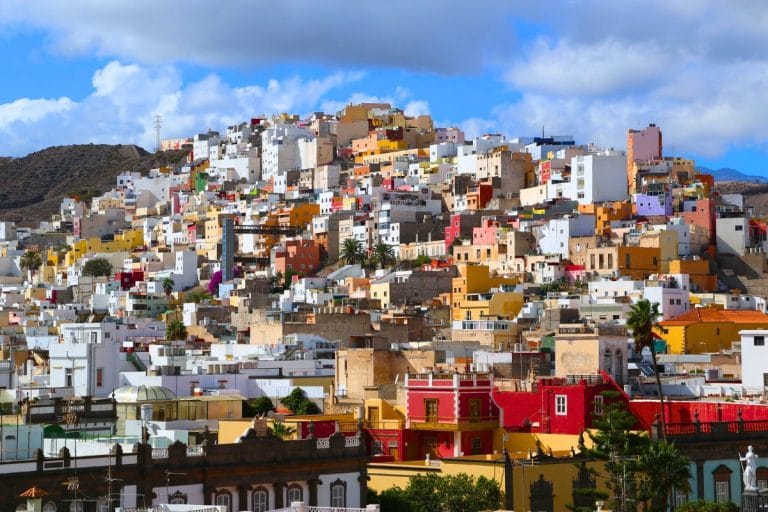 Vista panorámica de casas de colores en una colina de Las Palmas de Gran Canaria, con cielo parcialmente nublado.