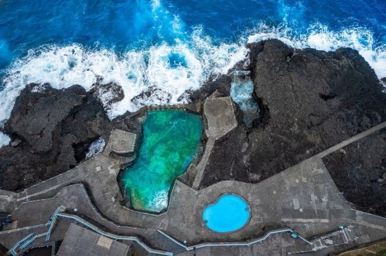 Vista aérea del Charco Azul, piscina natural entre rocas con agua turquesa y piscina azul junto al océano en La Palma