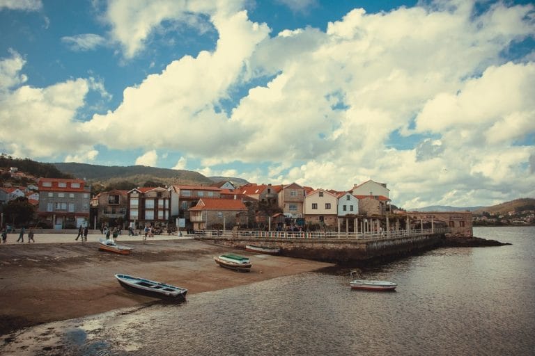 Vista costera del pintoresco pueblo de Combarro, Pontevedra, con sus casas tradicionales frente al mar y barcas de pesca varadas en la or orilla.
