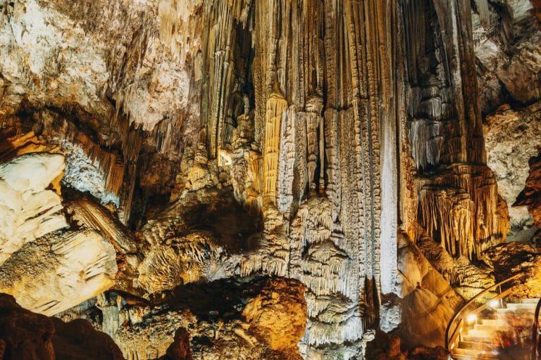 Interior de las Cuevas de Nerja en Málaga con estalactitas y estalagmitas iluminadas y escaleras para el recorrido turístico