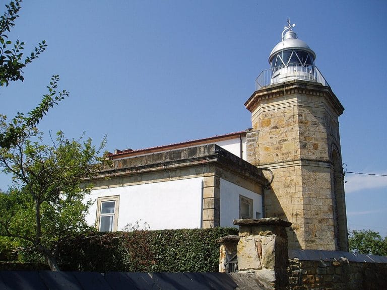 Faro de Tazones en Asturias, construcción histórica junto al mar Cantábrico rodeada de vegetación
