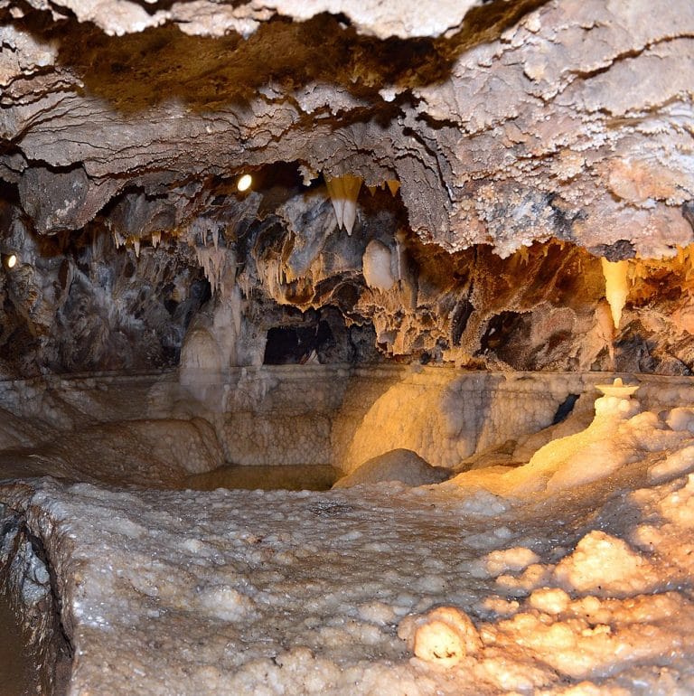 Interior de la Gruta de las Maravillas en Aracena con formaciones de calcita y estalactitas iluminadas