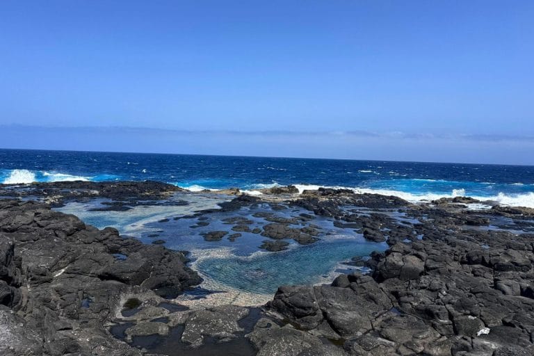 Piscinas naturales de Los Charcones en Lanzarote formadas entre rocas volcánicas frente al océano Atlántico