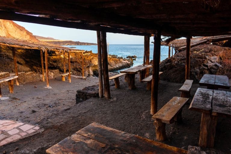 Zona de merenderos rústicos con mesas de madera junto al mar en Tacorón, en la isla de El Hierro