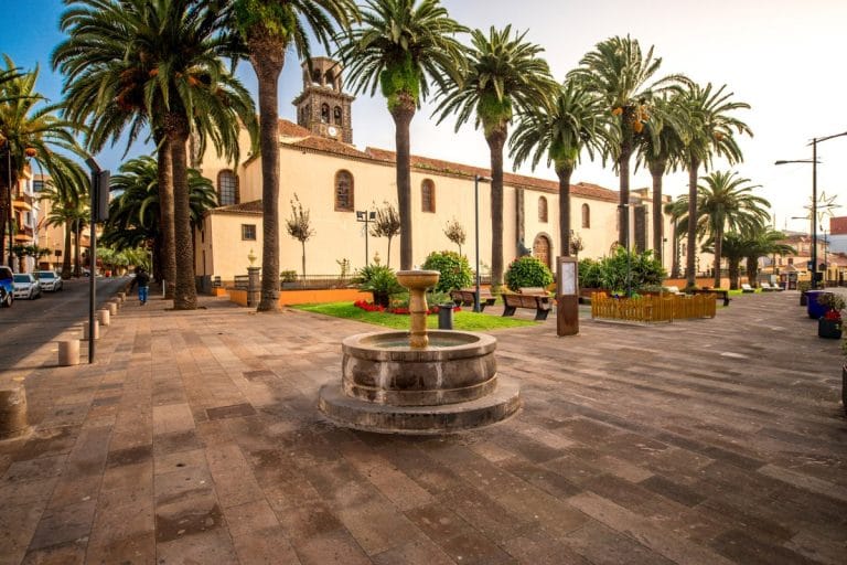 Vista de la Plaza de la Concepción en San Cristóbal de La Laguna con la emblemática iglesia y palmeras al atardecer