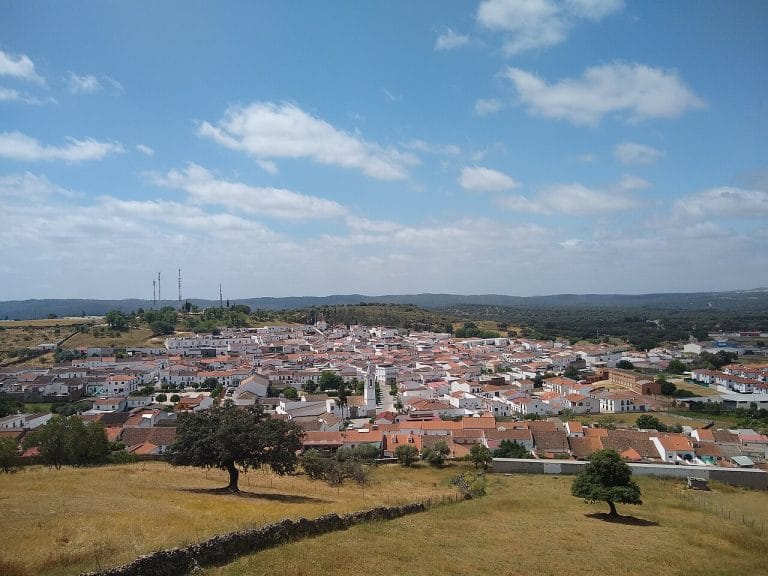 Panorámica de El Real de la Jara, pueblo blanco andaluz rodeado de dehesas y montañas al fondo
