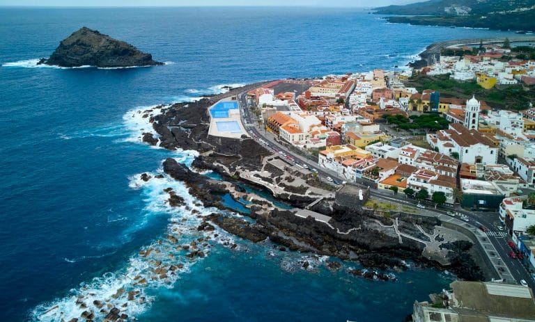 Vista aérea del pueblo de Garachico en Tenerife, con sus casas tradicionales, la costa volcánica, las piscinas naturales y el islote frente al mar