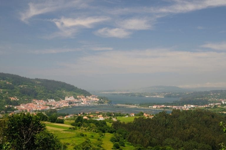 Vista panorámica de Pontedeume y la ría desde un mirador en Galicia, con paisaje verde y cielo despejado