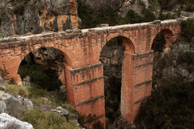 Vista del acueducto romano de Peña Cortada entre las montañas de Calles, Valencia, con arcos de piedra sobre un profundo barranco