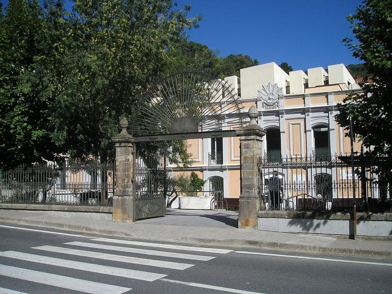 Fachada del balneario de Baños de Montemayor en Cáceres, edificio histórico con reja y portal monumental