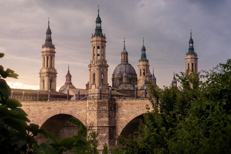 Vista de la Basílica del Pilar en Zaragoza detrás del Puente de Piedra al atardecer
