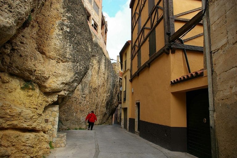 Calle estrecha entre pared de roca y casas tradicionales en Margalef, Priorat