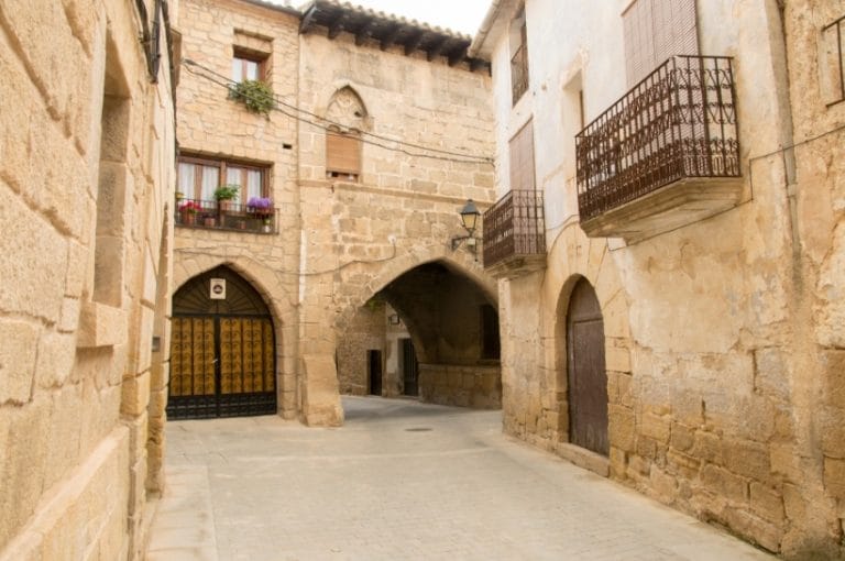 Calle medieval con arcos de piedra en el casco histórico de Cretas, Teruel