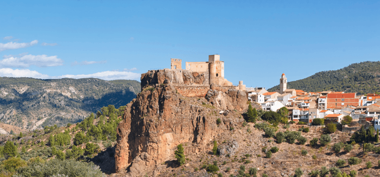 Vista panorámica del castillo de Cofrentes y el río Júcar rodeado de vegetación en la provincia de Valencia