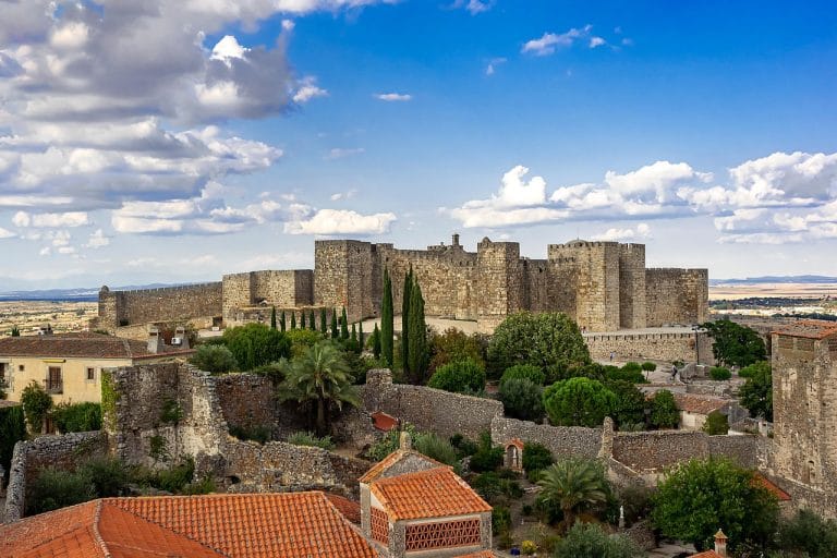 Vista del Castillo de Trujillo rodeado de vegetación y murallas medievales en Cáceres, Extremadura