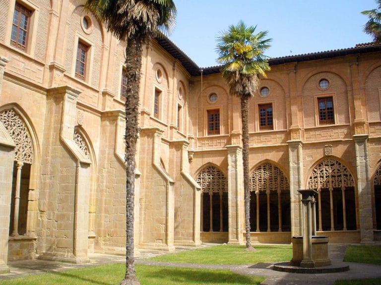 Claustro del Monasterio de Santa María la Real en Nájera, La Rioja, con palmeras y arquitectura gótica