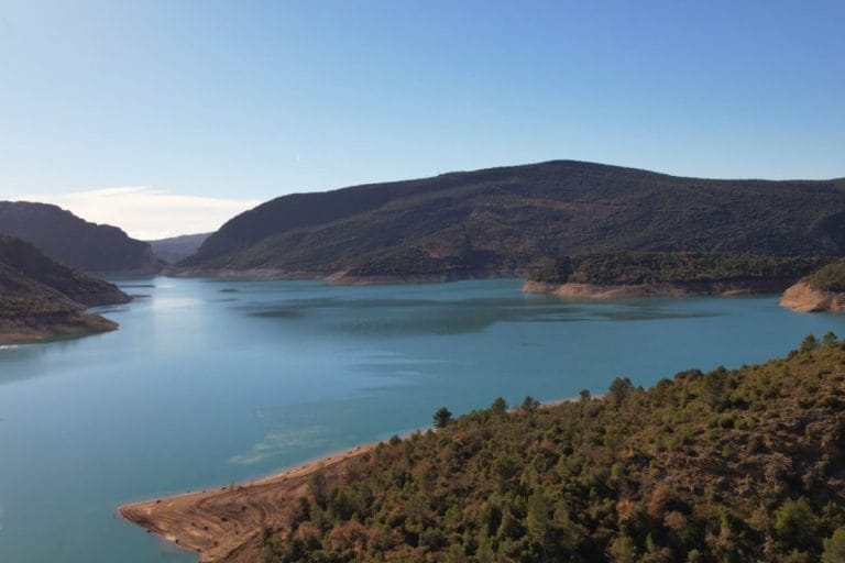 Vista panorámica del embalse de Canelles con sus aguas turquesas y la impresionante formación rocosa conocida como la Muralla de Finestres, un pliegue vertical de roca en el paisaje