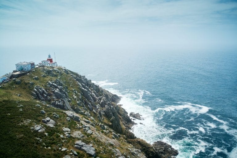 Vista aérea del faro de Finisterre sobre los acantilados de la Costa da Morte en Galicia