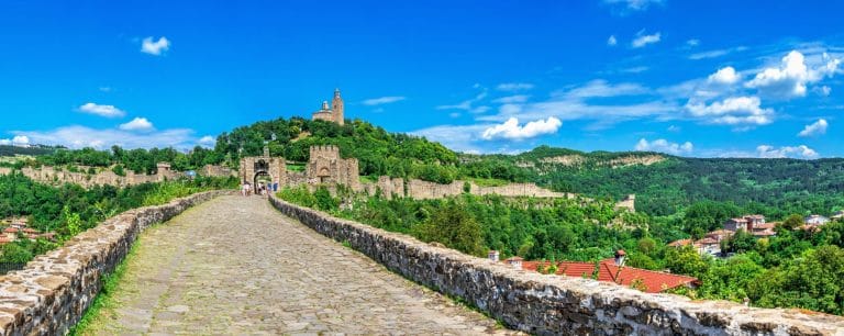 Entrada a la fortaleza Tsarevets en Veliko Tarnovo rodeada de murallas y colinas verdes