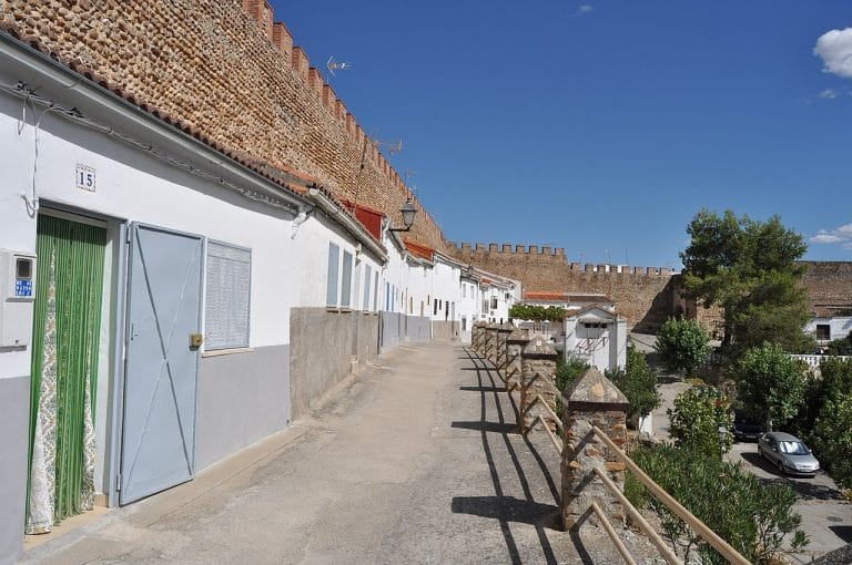 Calle con casas blancas junto a la muralla medieval de Galisteo en Cáceres