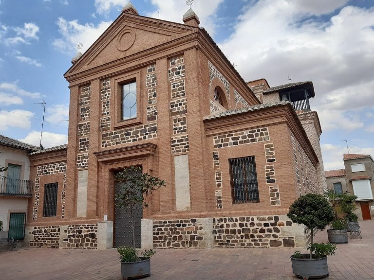 Vista frontal de la Iglesia Parroquial de Nuestra Señora de la Asunción en Calzada de Calatrava, con su fachada de ladrillo y piedra volcánica