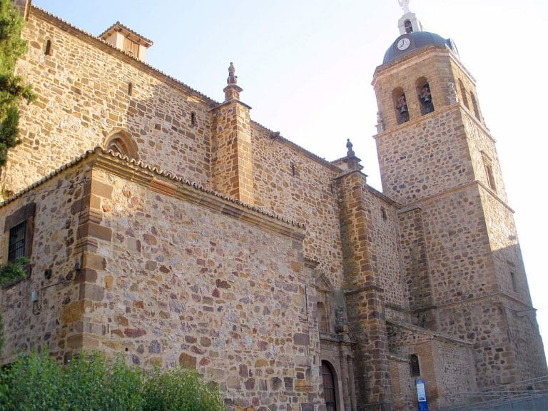 Iglesia de Nuestra Señora de la Asunción en Puertollano, con fachada de piedra y torre campanario