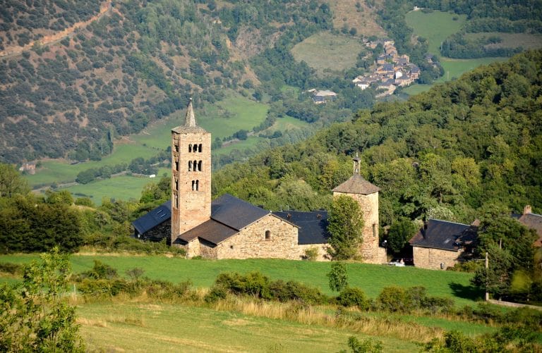 Iglesia románica en Alt Àneu, en el Pirineo de Lleida, rodeada de prados verdes y montañas del valle de Àneu