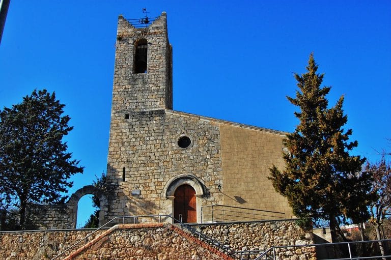 Iglesia de Sant Pau d'Ordal en Subirats con cielo azul despejado y fachada de piedra medieval